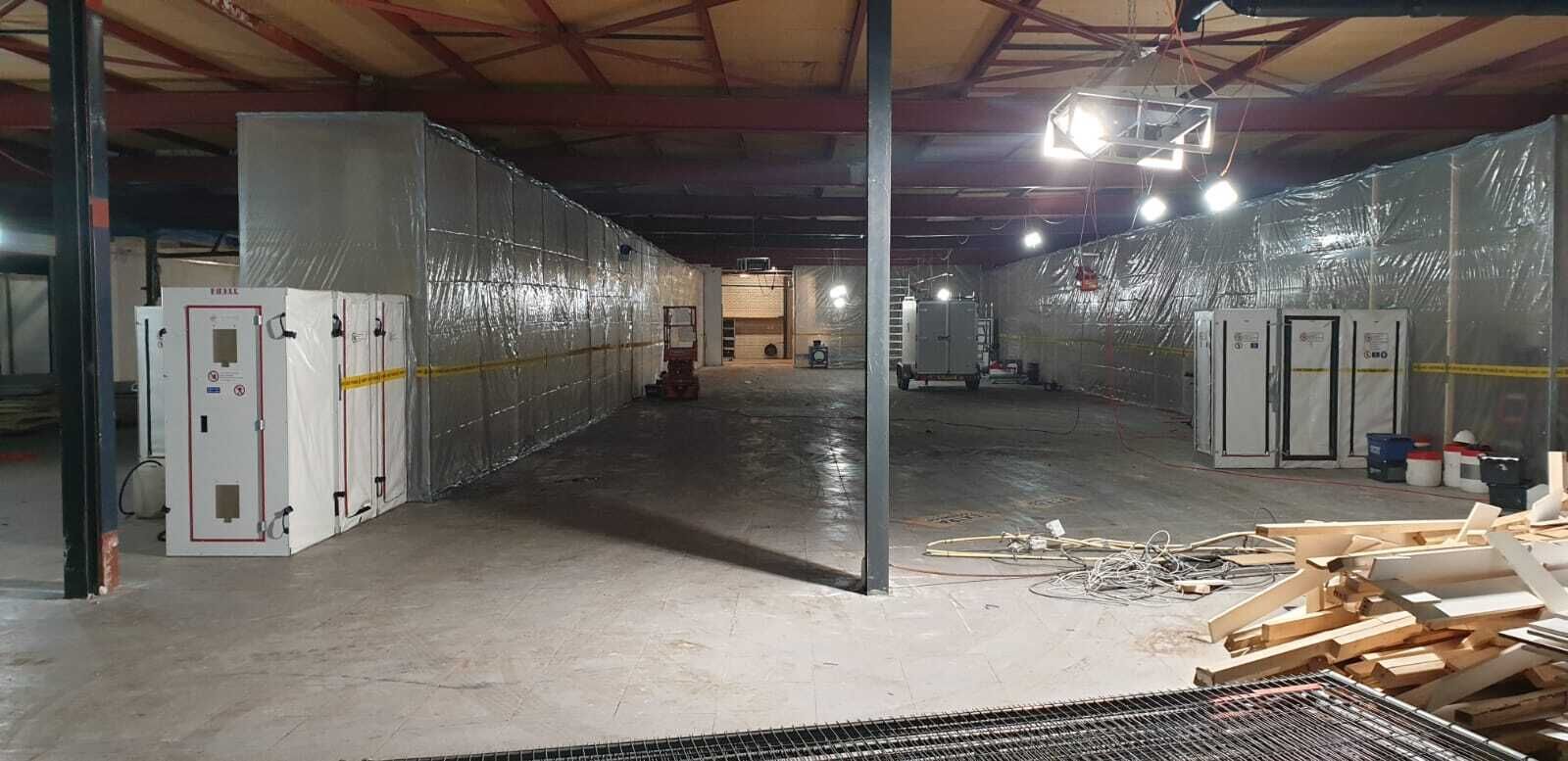 Grote saneringszone in bedrijfshal met luchtreinigers